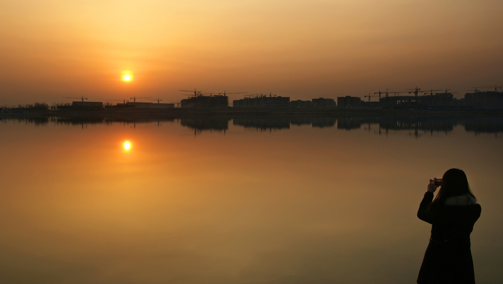 1月7日，在克拉玛依工程教育基地红山湖旁，市民正在观落日。