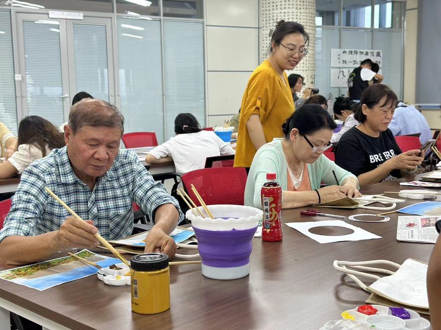 图9：银龄教师在“润物生艺术社”认真作画